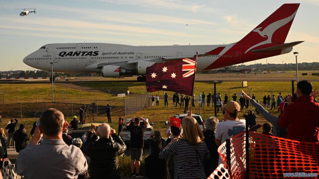 People watch as the last Qantas Boeing 747 airliner prepares to take off from Sydney airport.